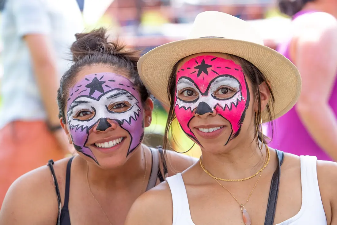 Two attendees with Lucha Libre face paint