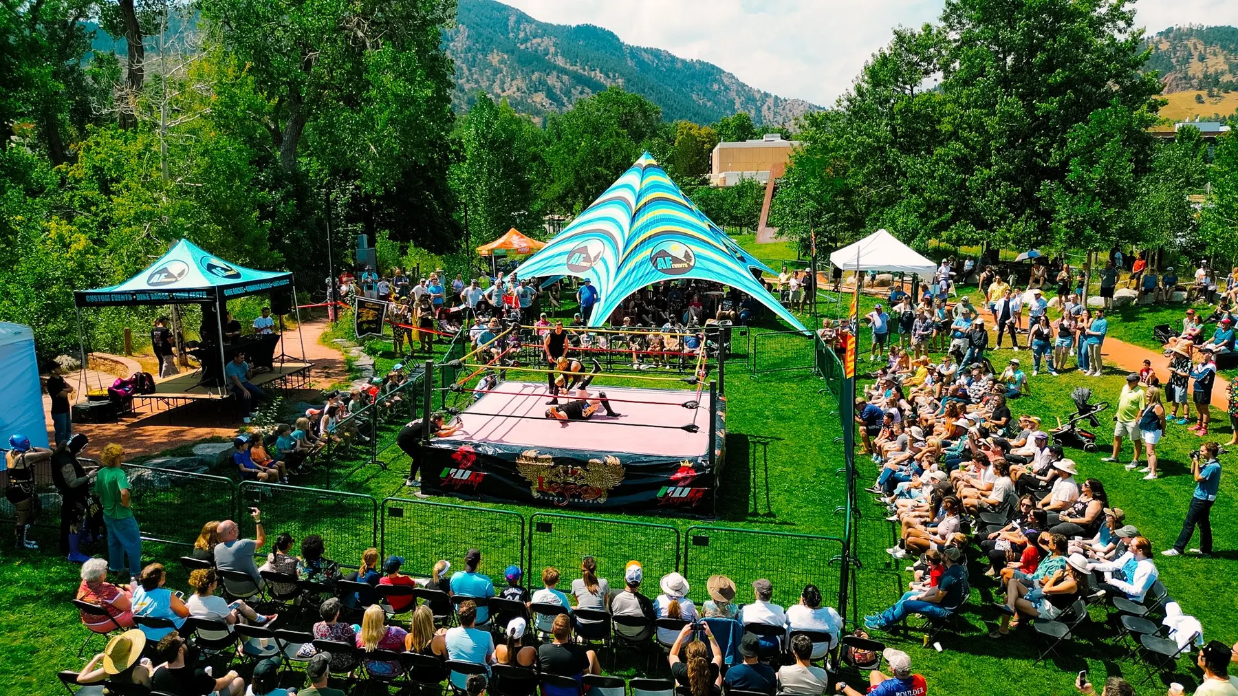 Lucha Libre wrestling ring at Boulder Taco Fest, ringed by the crowd and Flatirons mountains