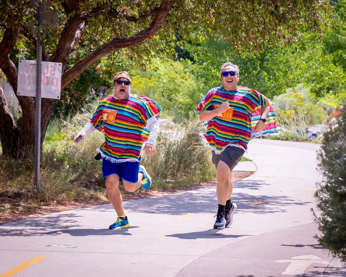 Runners in colorful serape ponchos finishing the 5K